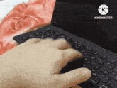 a person typing on a keyboard with a k on the bottom right