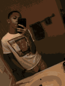 a young man is taking a selfie in the bathroom mirror