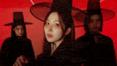 a woman wearing a black hat is surrounded by other women