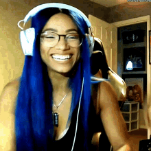 a woman with blue hair wearing headphones and glasses