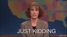 a woman in a suit is saying just kidding in front of a map of the united states