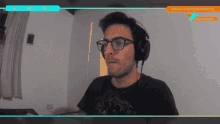 a man wearing glasses and headphones is sitting in front of a monitor that says monday 14 september 2020