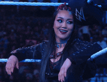 a woman standing in a wrestling ring with a n on her hat