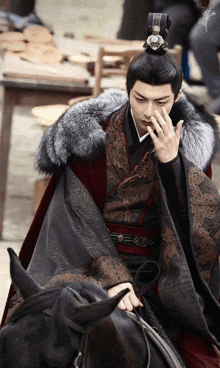 a man in a traditional costume is sitting on a horse