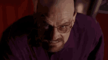 a man with glasses and a beard is giving the middle finger to the camera .