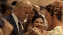 a man in a suit and tie is standing next to a woman in a white dress at a party .