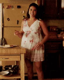 a woman in a white dress is standing in front of a refrigerator with a magnet that says ' i love you '