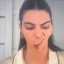 a close up of a woman making a face with her tongue out .