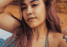 a woman with pink hair has a nose ring