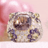 a ring with purple and yellow stones and a large purple diamond