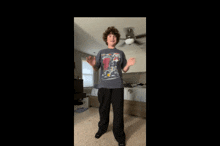 a young man wearing a t-shirt with a picture of a car on it is standing in a bedroom