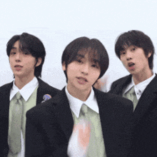 three young men in suits and ties are posing for a picture .