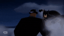 a man in a black hat is standing next to a batman in a cartoon .