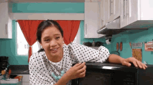 a woman in a kitchen with a sign that says bon appetite