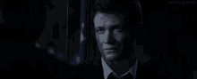 a man in a suit and tie looks at the camera