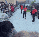 a woman in a red shirt stands in a crowd of people