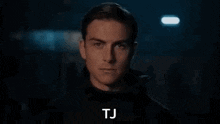a close up of venom 's face in a dark room with the words tj written on the bottom .