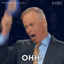 a man in a suit and tie is making a funny face and saying ohh