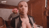 a woman with a tattoo on her chest is standing in a room with other women