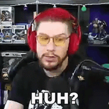 a man with red hair and a beard is wearing headphones and sunglasses and making a funny face .