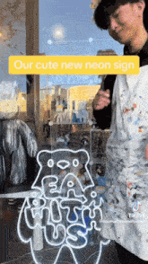 a man is standing in front of a sign that says eat with us