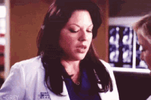 a woman in a white lab coat with the word grey on her chest