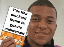 a man holding up a card that says t'as flop clochard ferme ta gueule maintenant