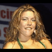 a woman in a green bikini is smiling in front of a sign that says cir