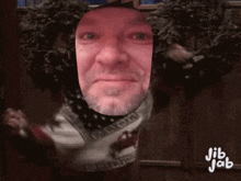 a man 's face is cut out of a sweater with jib jab written on it