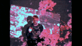 a man is surrounded by pink flowers and a purple background