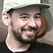 a man with a beard wearing a white hat and smiling