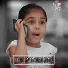 a little girl talking on a cell phone with the words bohut saara cheese khaya written below her