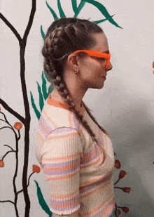 a woman wearing a striped shirt and orange sunglasses