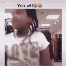 a man with dreadlocks is standing in front of a store .