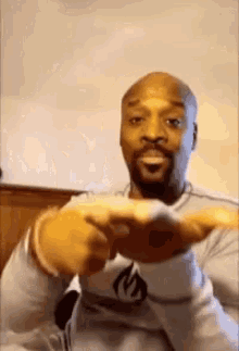 a bald man with a beard is holding something in his hand