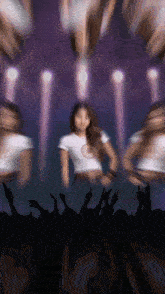 a woman in a white shirt with the letter c on her chest is dancing in front of a crowd