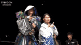 two women are standing next to each other in a wrestling ring with the word stardom on the bottom right