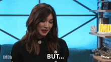 a woman is sitting on a blue couch and says but
