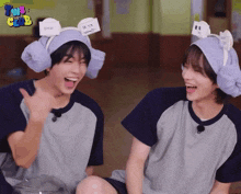 two boys wearing towels on their ears are laughing in front of a sign that says tnb club