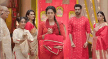 a woman in a red dress is standing in front of a group of people in red clothes .