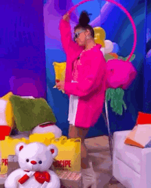 a woman in a pink jacket is holding a hula hoop in front of a teddy bear
