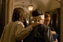 a man with a bandage on his head is being comforted by a woman