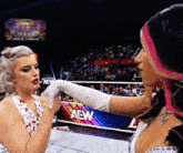 two women wrestling in front of a aew banner