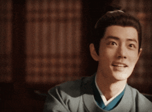 a young man in a traditional costume is smiling and looking at the camera