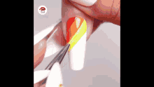 a person is painting their nails with a brush and a rainbow design .