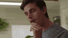 a close up of a man 's face with his hand on his mouth .