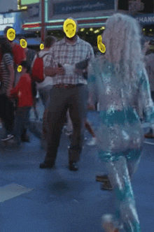 a man with a smiley face on his face stands next to a woman in a sequined outfit