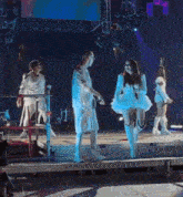 a man and a woman are holding hands on a stage while dancing .