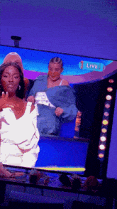 two women are on a television screen with a live sign above them