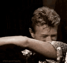 a man is covering his face with his hand while crying .